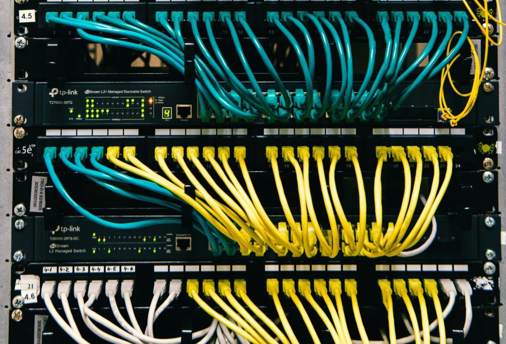 Several plugs connected to a server in a data center, using significant energy to power the servers. 
